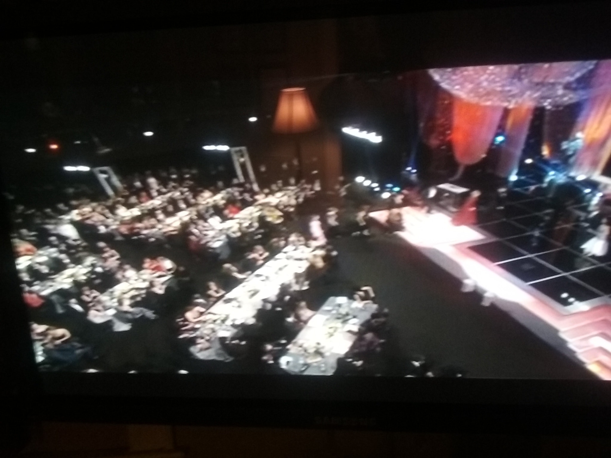 Concert crowd seated under stage lights — live venue AV