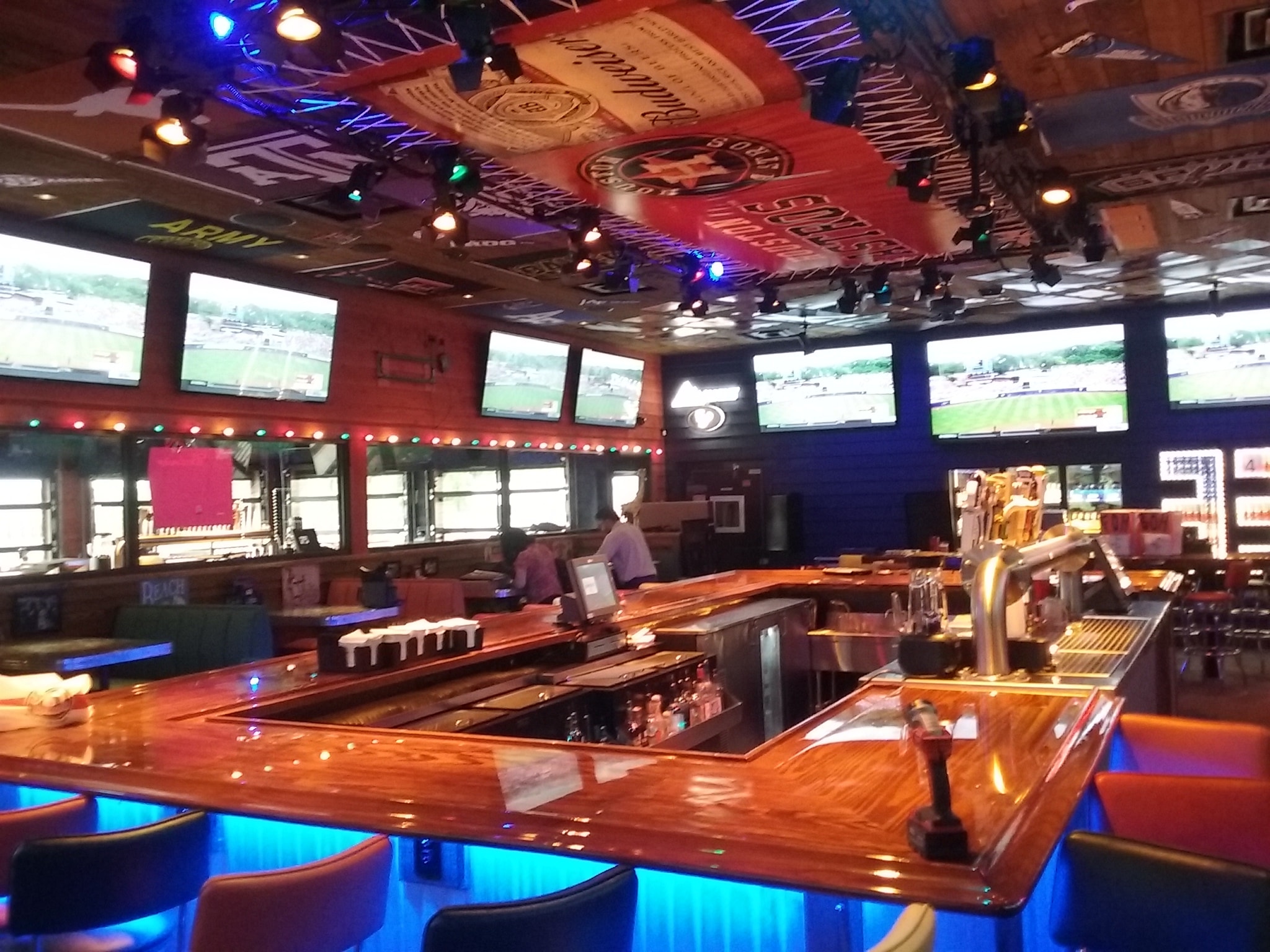 Sports bar interior with neon lighting and multiple screens installed