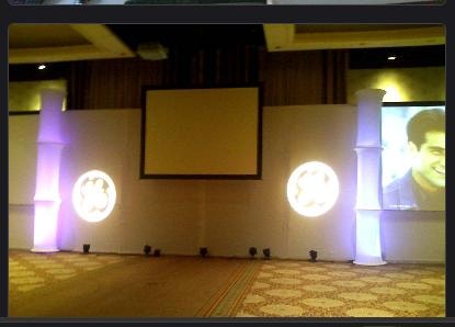 Live corporate event with projection screen and illuminated columns on stage
